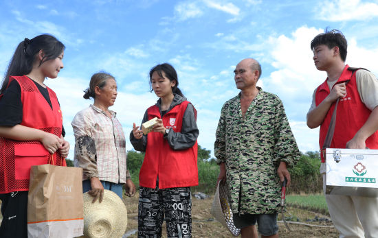 7月3日，湖南省衡阳市珠晖区酃湖乡，太阳成集团tyc33455cc护理公司的志愿者给在田间地头忙碌的乡亲送去防暑的药品。曹正平 摄